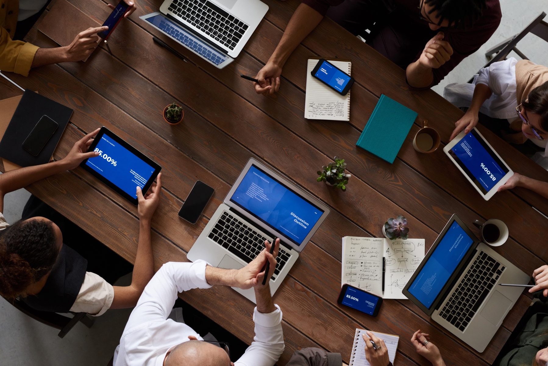 Photo Of People Leaning On Wooden Table working