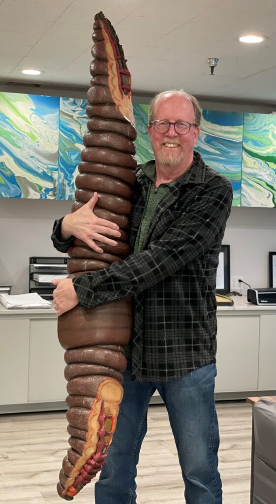 Patrick Mathews holding a model of a worm